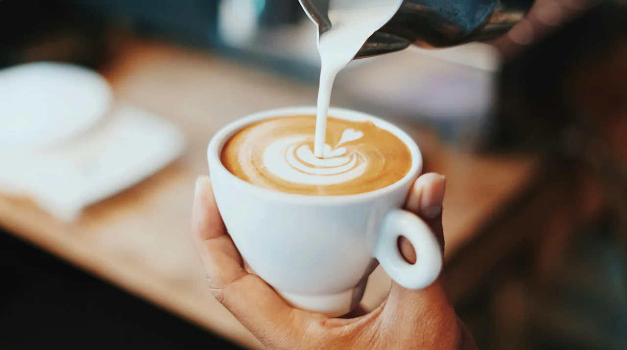Latte Art wird in eine Tasse Kaffee gegossen