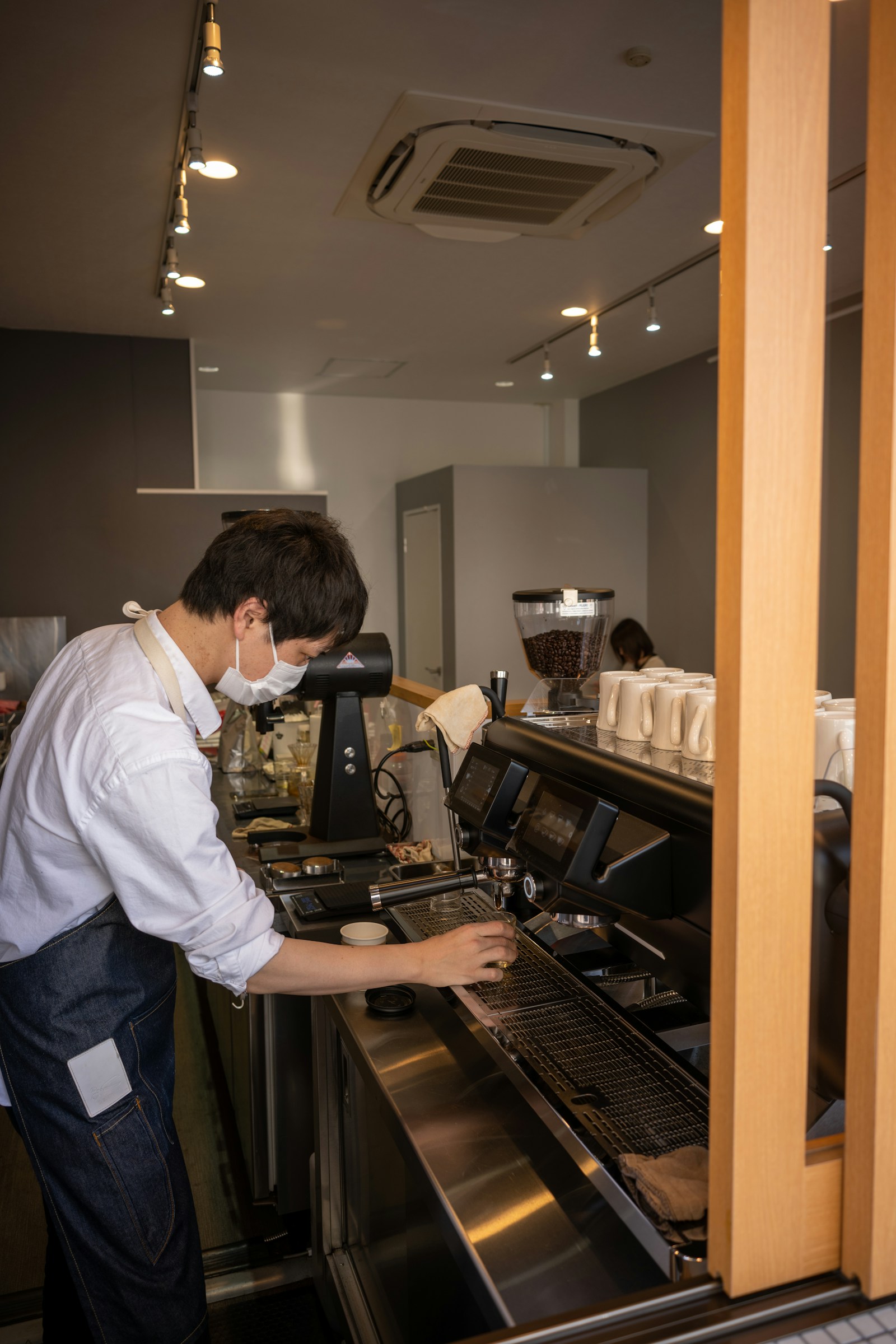 Person arbeitet an einer professionellen Kaffeemaschine